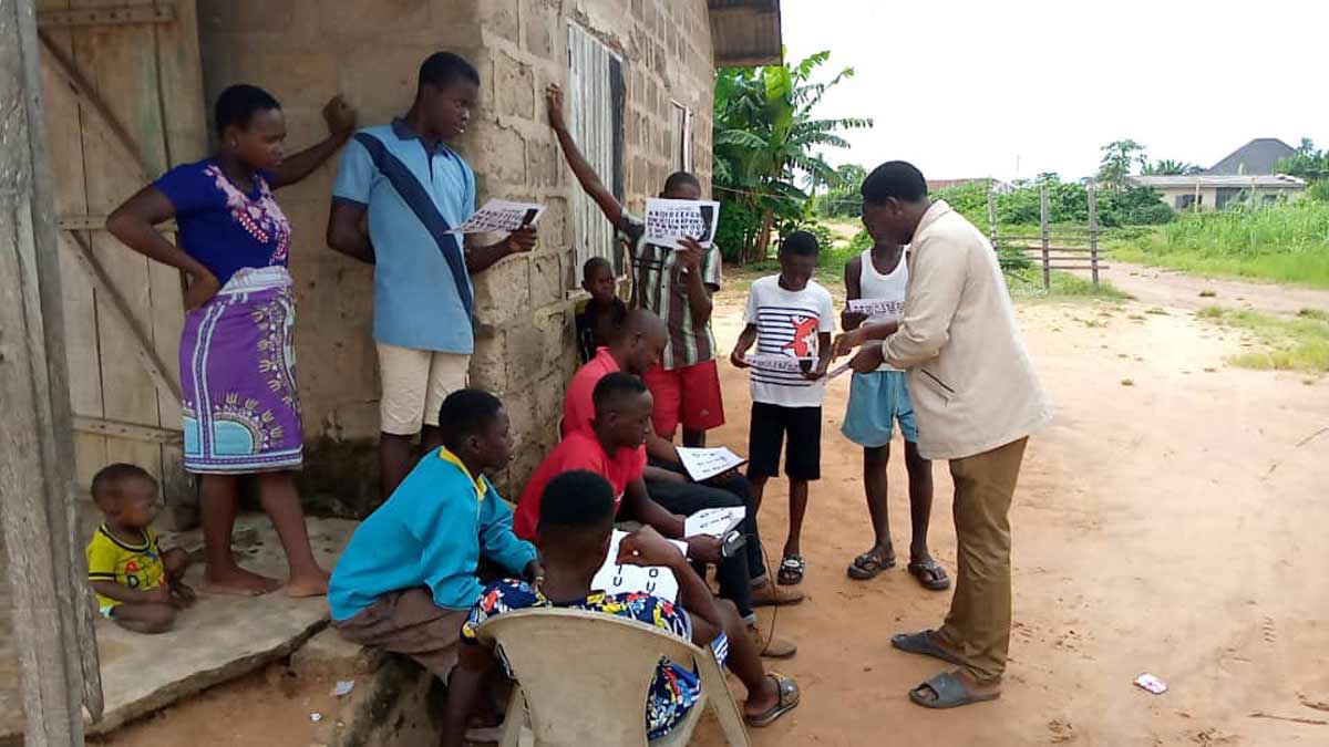 Group in front of a Ndokwa church hears and reads Scripture in their own language